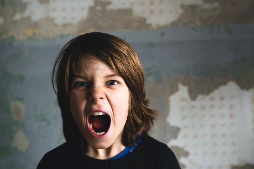 Symptoms, causes, and treatment of depression. Boy screaming with anger because of depression. Unsplash