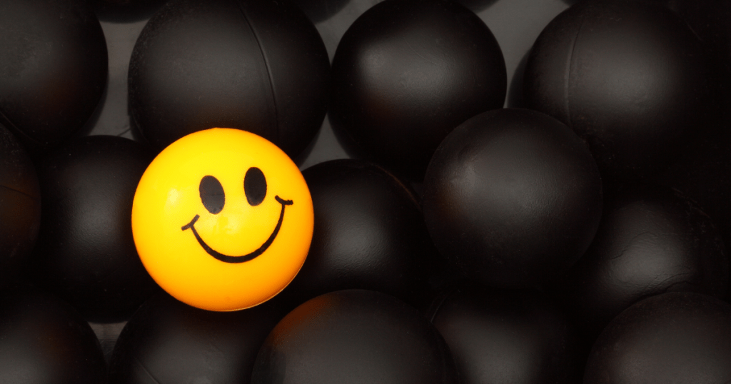 A yellow smilie ball with all black balls in the background. How to choose the right career path?