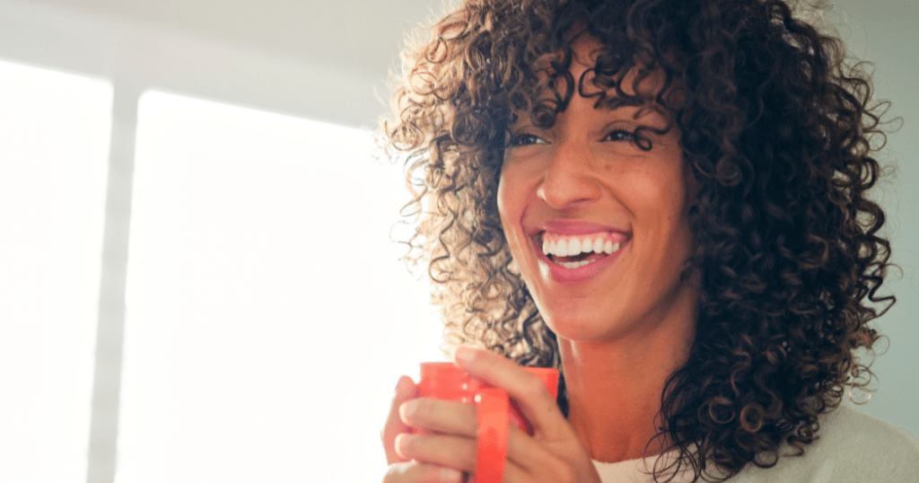 Woman cheerfully holding a cup of coffee. How to know you are on the right path?