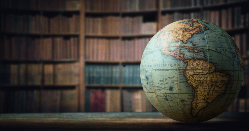 A globe on the table with a bookshelf in the background. Things to do when you fail.