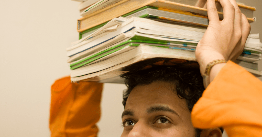  A boy holding books on his head.